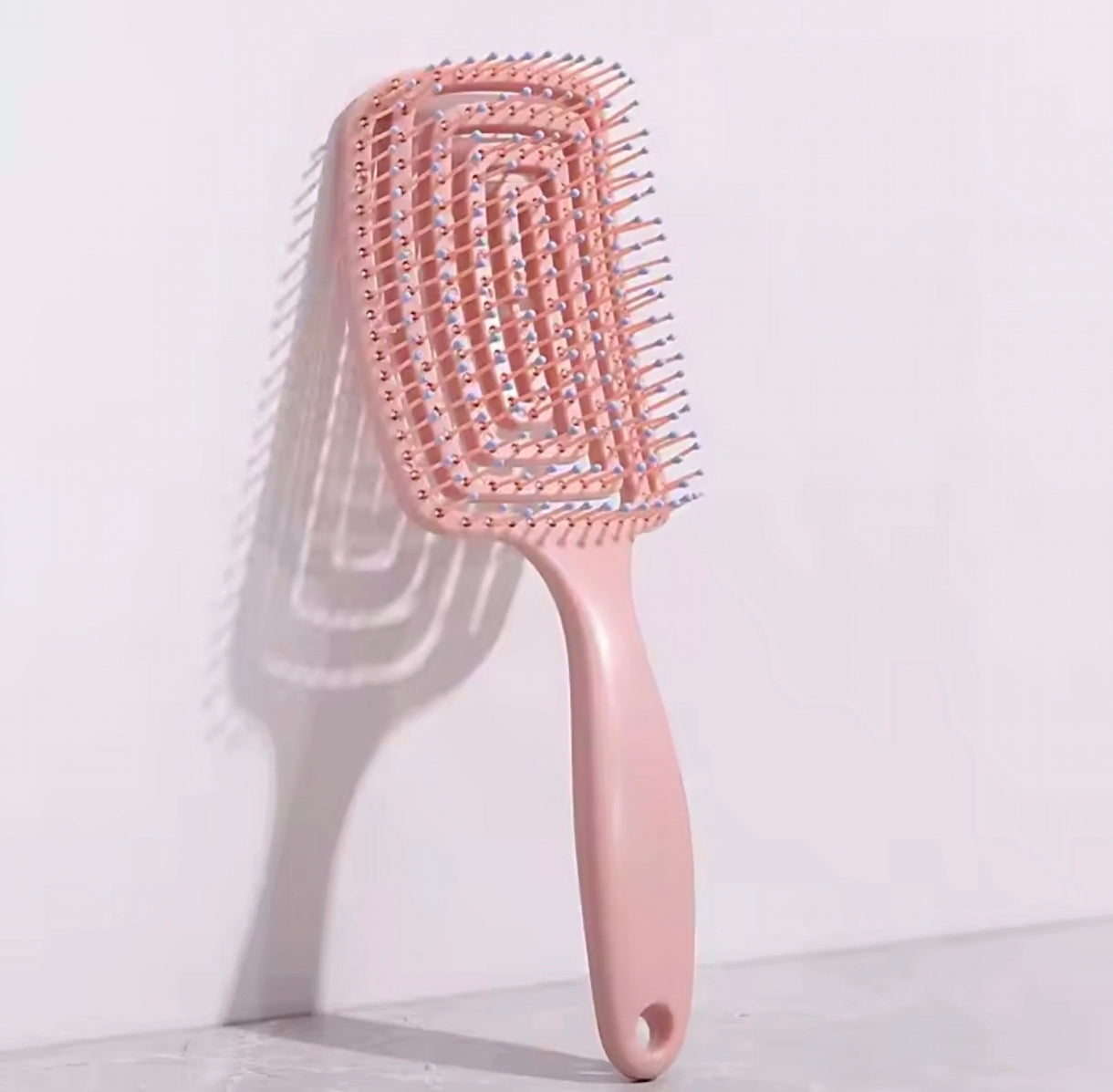 Brosse anti-frisottis utilisée sur cheveux bouclés, démêlage rapide, effet lisse et brillant